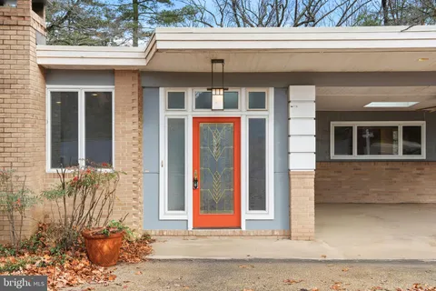 a front view of a house with a yard and potted plants