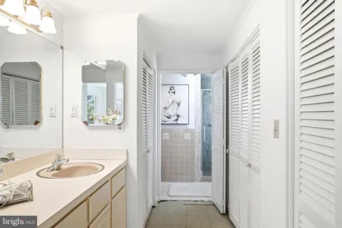 a en suite bathroom with a granite countertop sink and a mirror