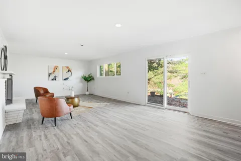 a view of empty room with wooden floor and lounge chair