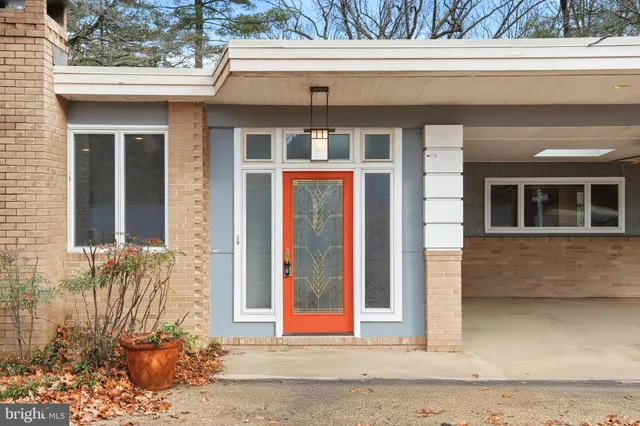 a front view of a house with a yard and potted plants