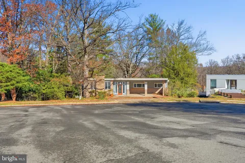 a front view of house with yard and trees around