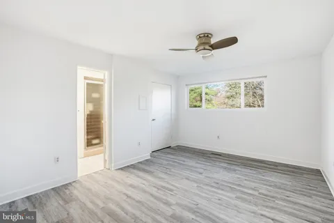 an empty room with wooden floor and window