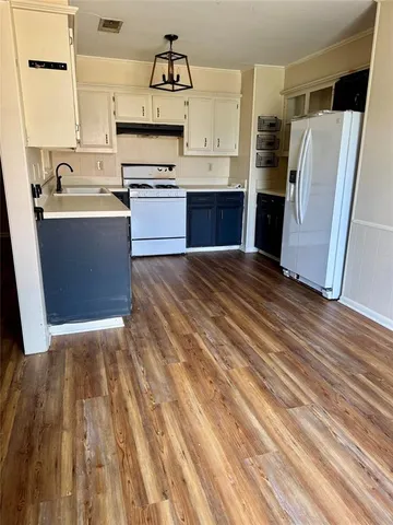 a kitchen with granite countertop a refrigerator and a sink