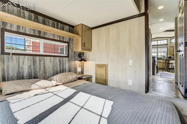 a bedroom with a bed and a large window