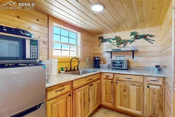 a kitchen with stainless steel appliances granite countertop a sink a counter space and a window