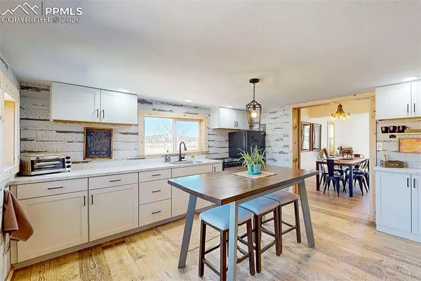 a kitchen with appliances cabinets table and chairs