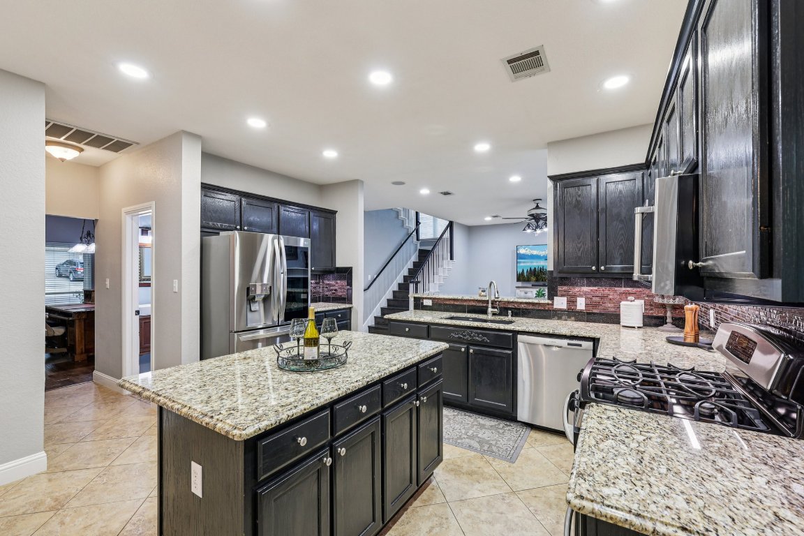 1108 Dalea Bluff Round Rock, TX 78665 - Photo 12 of 40 a kitchen with stainless steel appliances granite countertop a sink stove and refrigerator