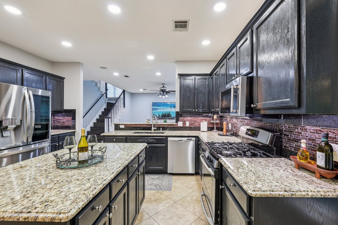 1108 Dalea Bluff Round Rock, TX 78665 - Photo 13 of 40 a kitchen with stainless steel appliances granite countertop a sink stove and refrigerator