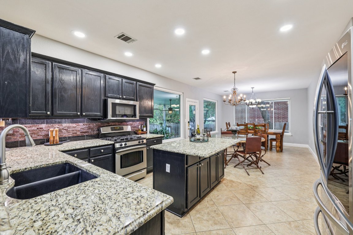 1108 Dalea Bluff Round Rock, TX 78665 - Photo 14 of 40 a kitchen with stainless steel appliances granite countertop a sink stove and refrigerator