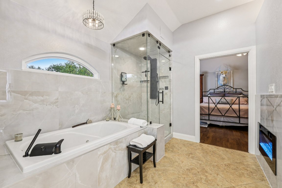 1108 Dalea Bluff Round Rock, TX 78665 - Photo 32 of 40 a en suite bathroom with a sink a mirror a bathtub and shower