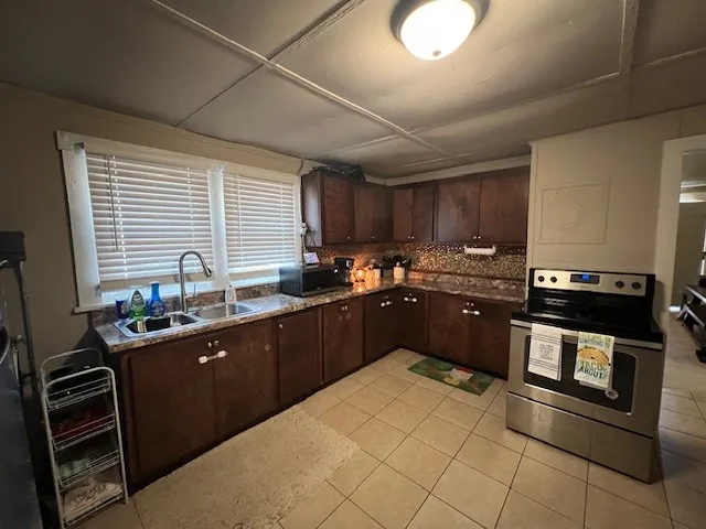 a kitchen with a stove sink and cabinets