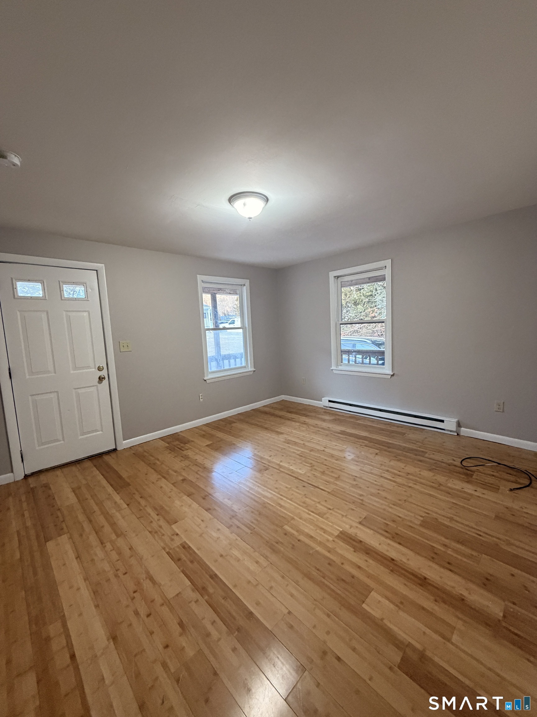 844 Field Street Naugatuck, CT 06770 - Photo 2 of 6 an empty room with wooden floor and windows