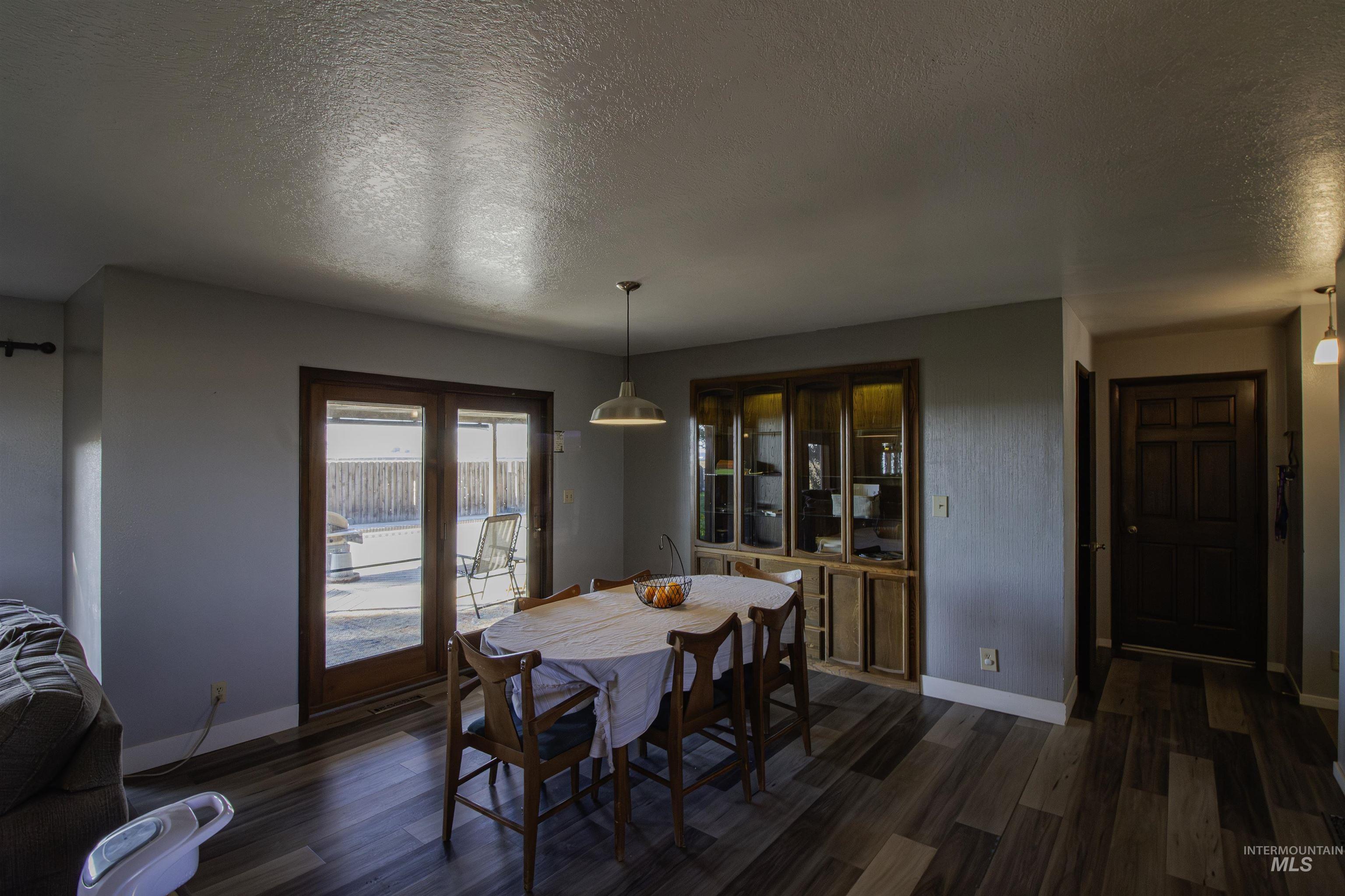 887 Overstreet Road Nyssa, OR 97913 - Photo 14 of 50 Dining area with a textured ceiling and dark wood-style flooring