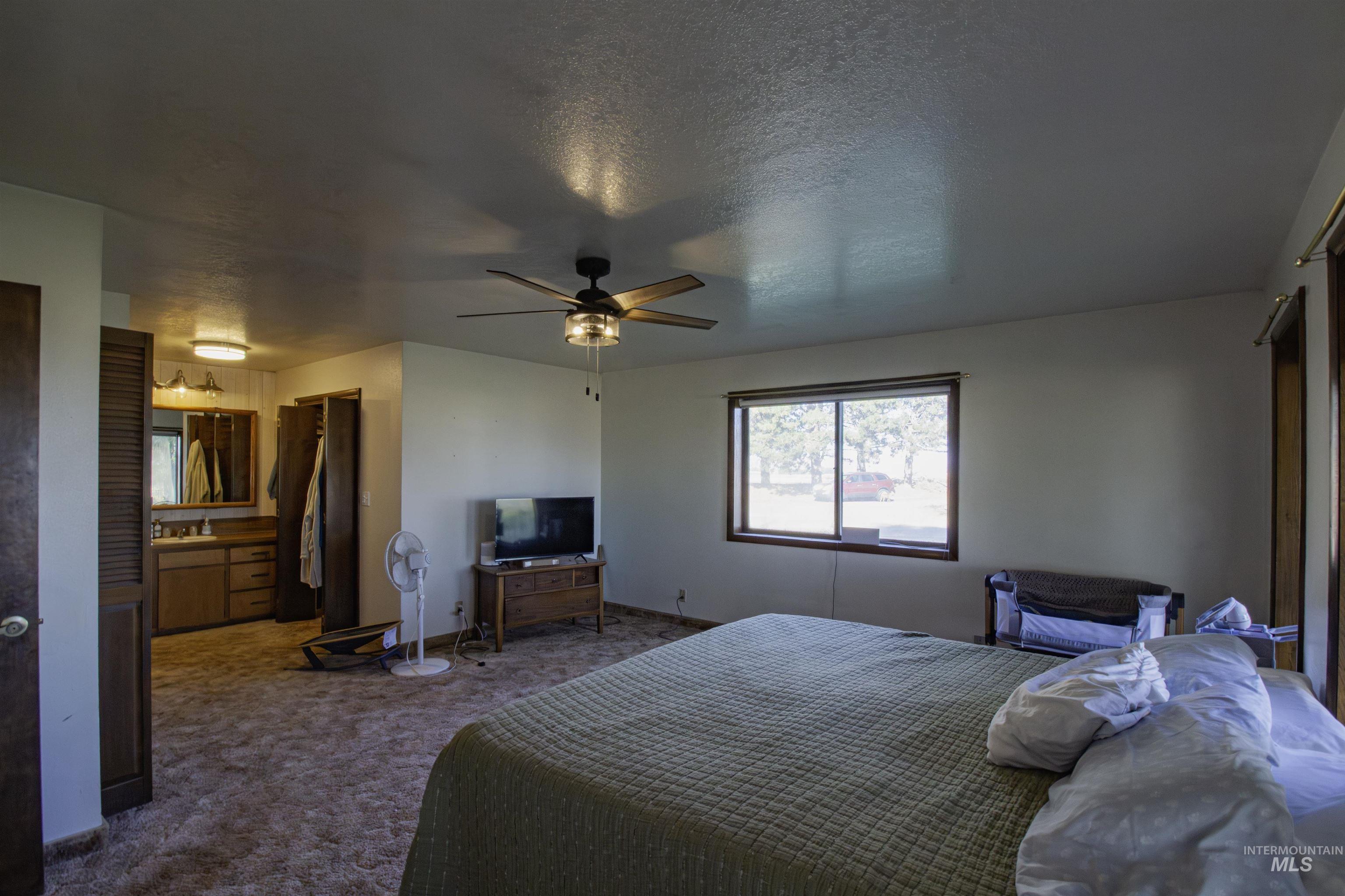 887 Overstreet Road Nyssa, OR 97913 - Photo 18 of 50 Carpeted bedroom featuring a textured ceiling, a closet, and ceiling fan