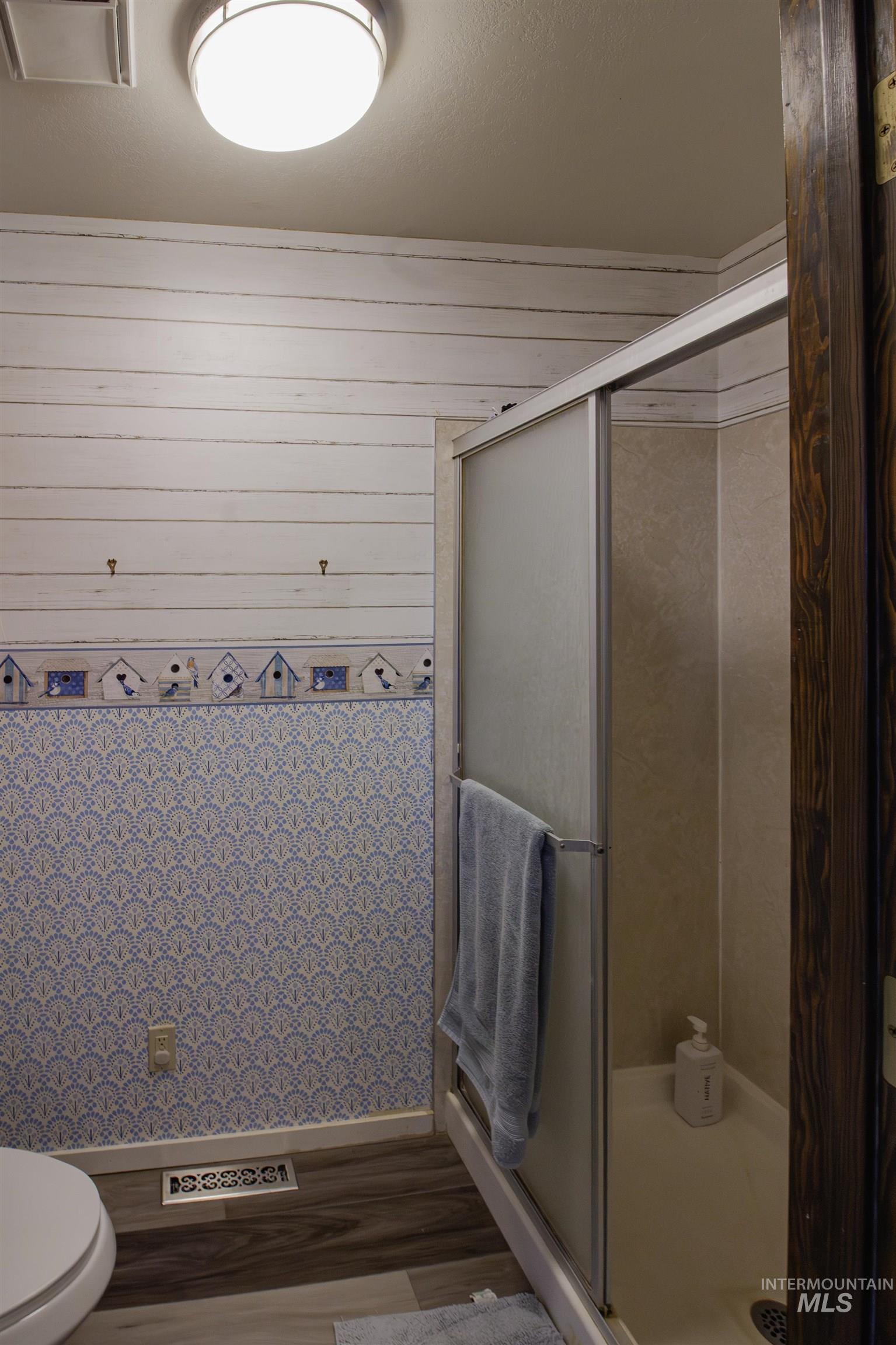 887 Overstreet Road Nyssa, OR 97913 - Photo 21 of 50 Bathroom featuring a stall shower, wood finished floors, and wooden walls