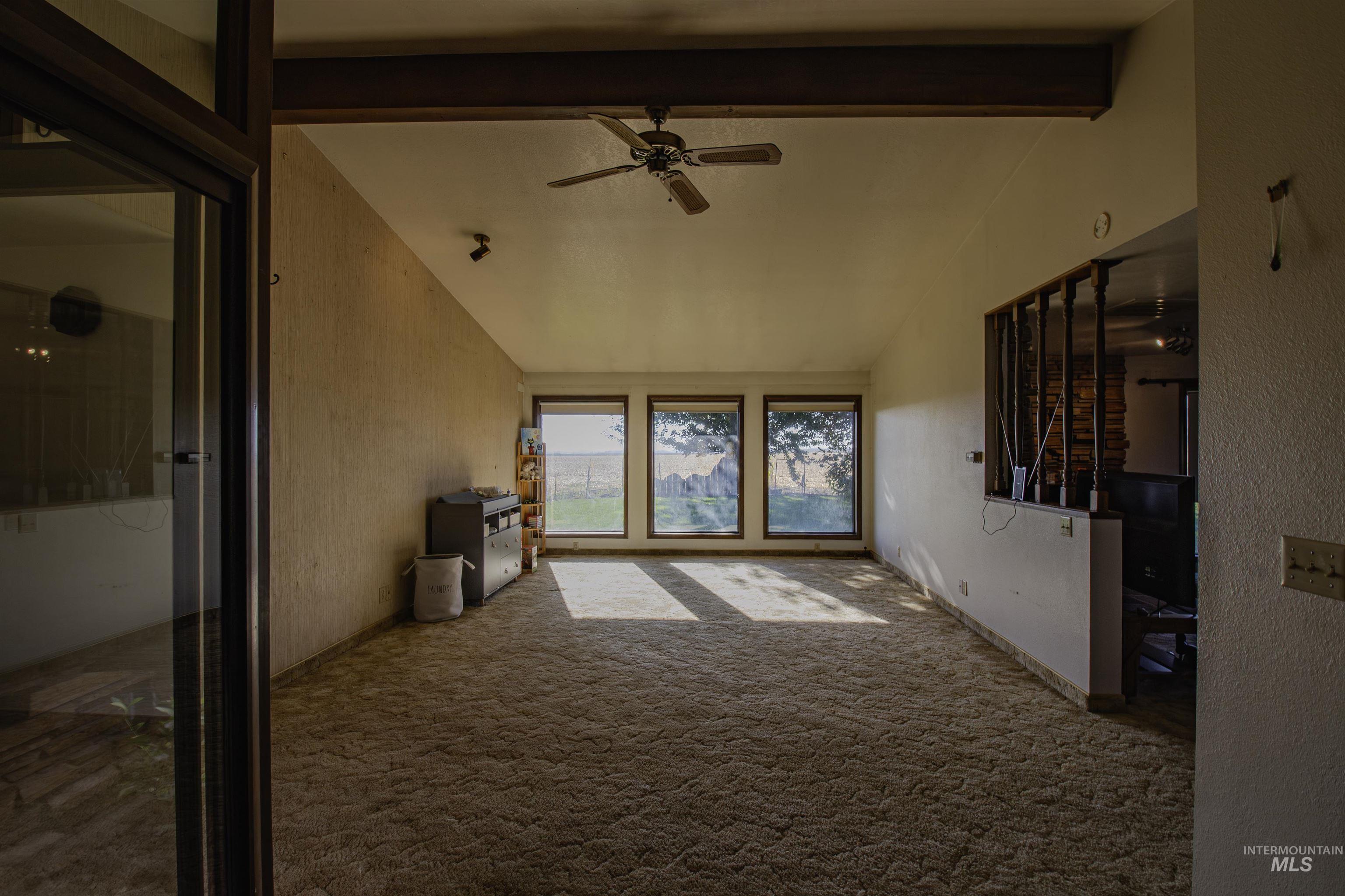 887 Overstreet Road Nyssa, OR 97913 - Photo 8 of 50 Unfurnished living room featuring carpet flooring, ceiling fan, and a textured wall