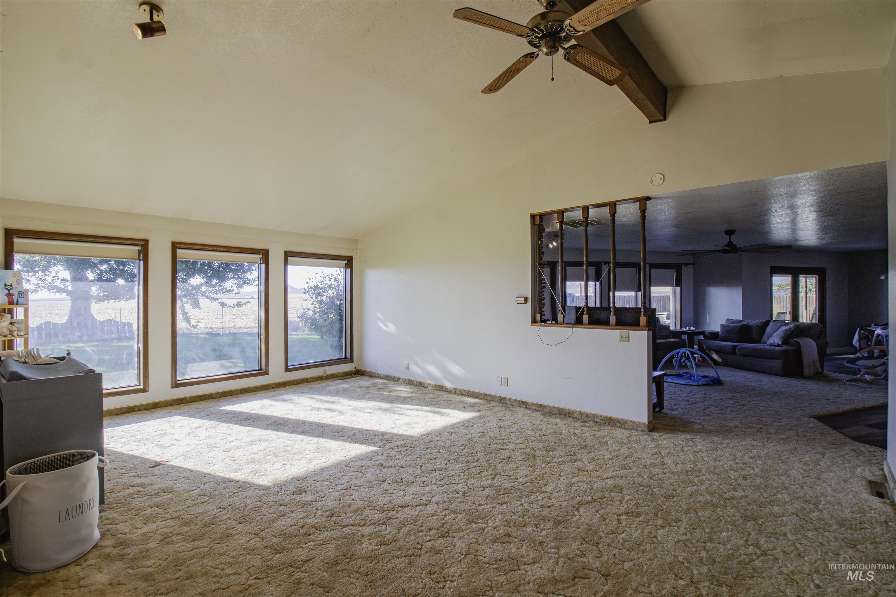 887 Overstreet Road Nyssa, OR 97913 - Photo 9 of 50 Carpeted living room with beamed ceiling, ceiling fan, and high vaulted ceiling