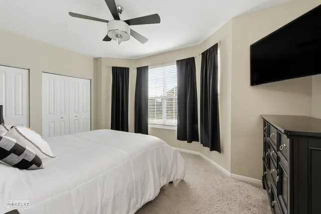 a bedroom with a bed tv and a window