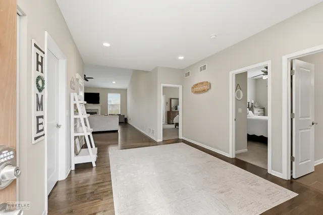 a view of a hallway with wooden floor and a living room