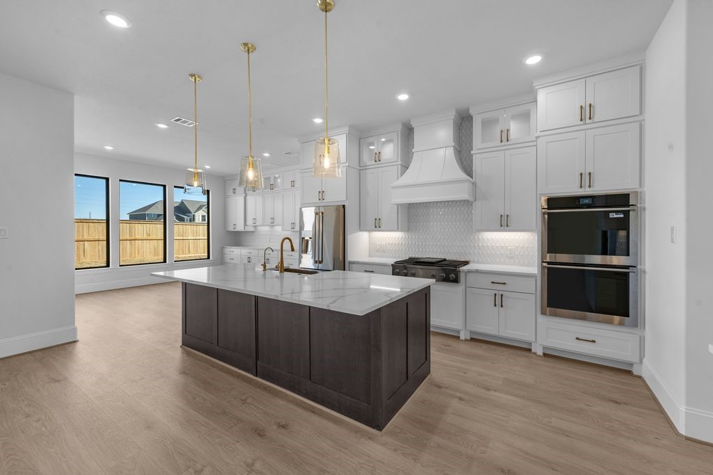 7703 Sparkle Dunn Court Fulshear, TX 77441 - Photo 6 of 26 TONS of cabinets in this kitchen! The island has TWO dishwashers!