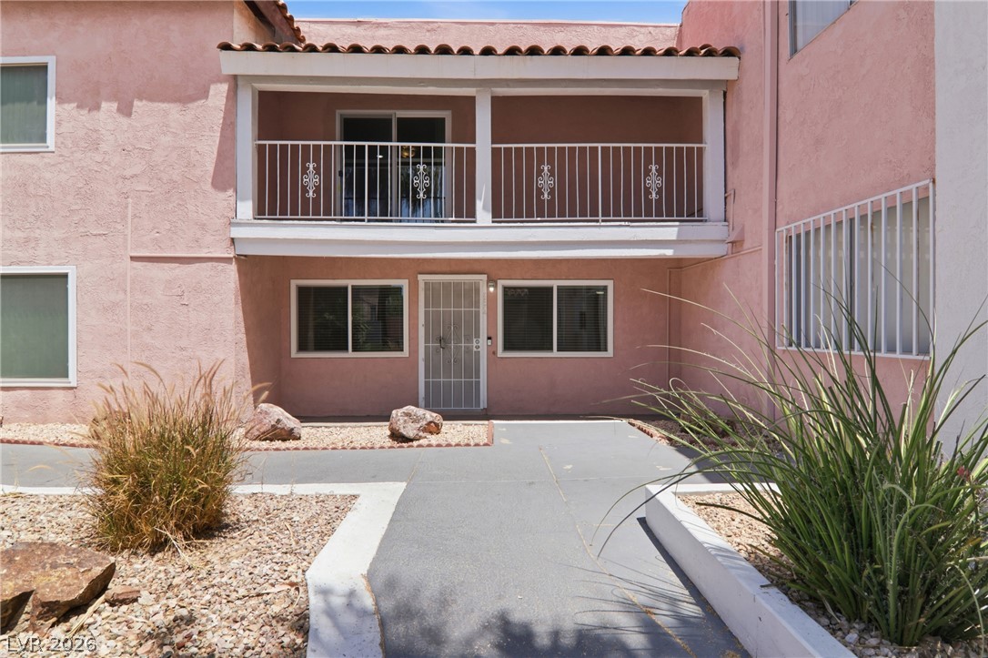 A charming facade presents an upper-level balcony with ornate railings and a tiled roof accent.