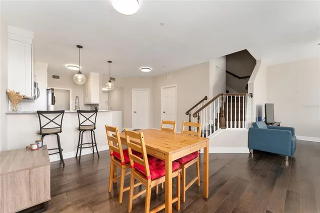 a kitchen with stainless steel appliances kitchen island granite countertop a refrigerator a stove and a sink with wooden floor