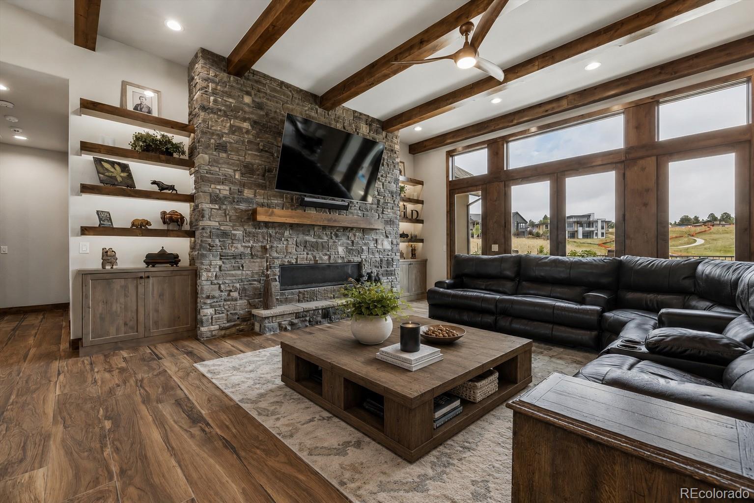 5754 Powell Road Parker, CO 80134 - Photo 6 of 43 a living room with furniture a flat screen tv and a fireplace