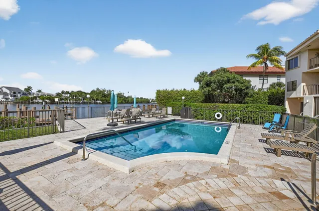 an aerial view of residential houses with outdoor space and lake view in back
