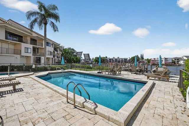 an aerial view of a city with lots of residential buildings ocean and mountain view in back