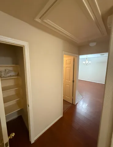 a view of a hallway with wooden floor and closet