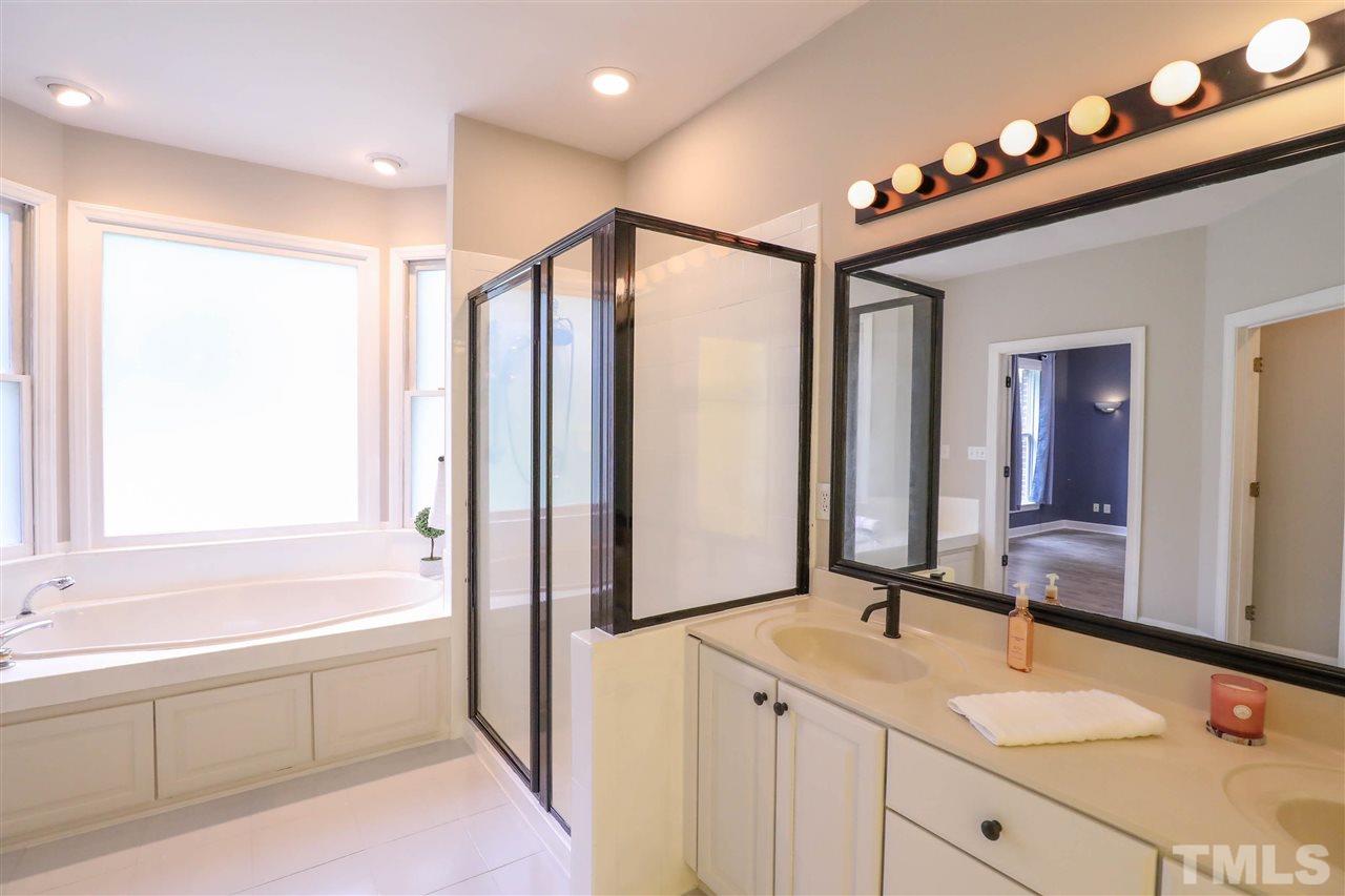 8925 Ball Road Bahama, NC 27503 - Photo 13 of 28 a spacious bathroom with a bathtub shower sink and mirror