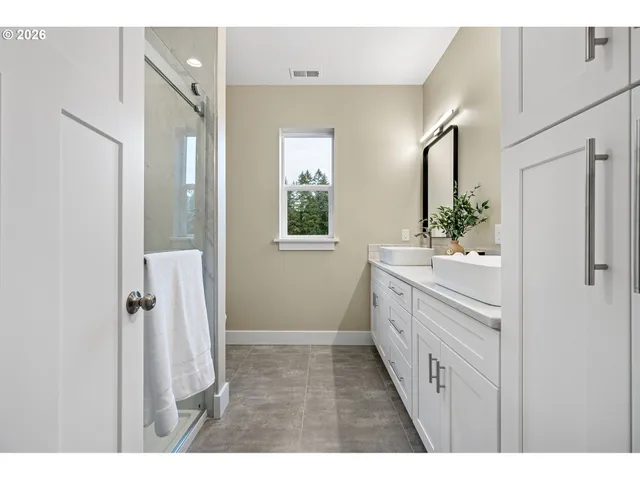 a bathroom with a double vanity sink a mirror and a shower