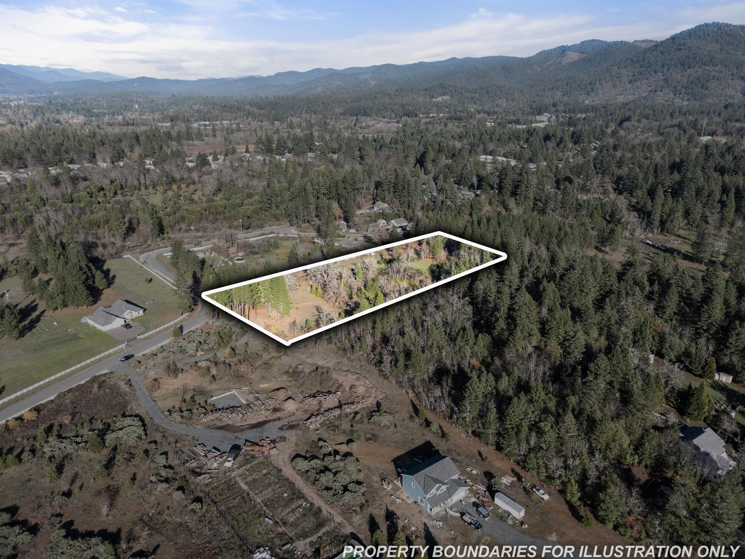 681 Daisy Hill Road Cave Junction, OR 97523 - Photo 25 of 26 a view of a forest with a mountain and trees in the background