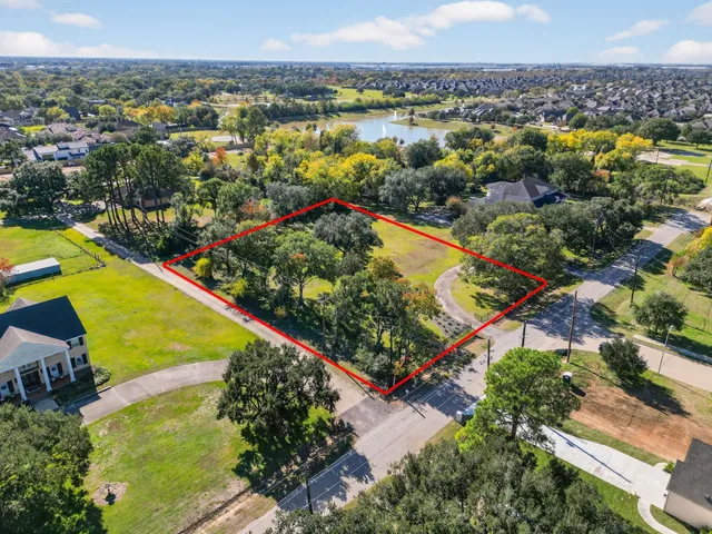 an aerial view of lake and residential houses with outdoor space