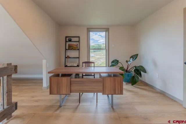 a living room with furniture a window and a potted plant