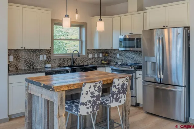 a kitchen with stainless steel appliances a stove a refrigerator and a sink