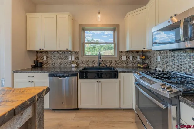 a kitchen with granite countertop a sink stove and cabinets