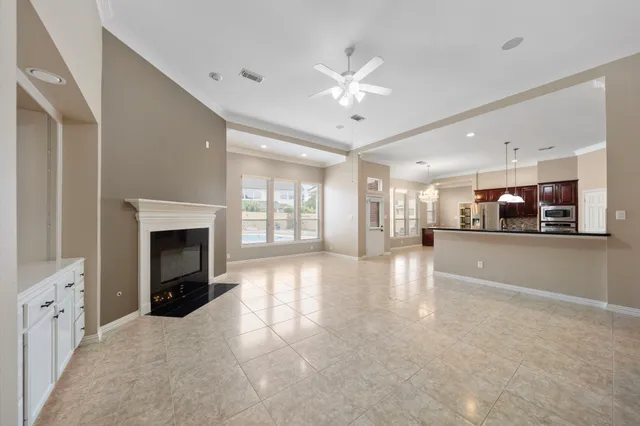 a view of an empty room with a fireplace and window
