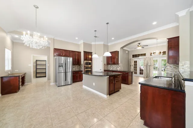 a large kitchen with stainless steel appliances kitchen island granite countertop a refrigerator and stove top oven with a dishwasher