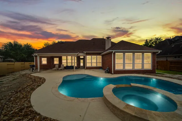 a view of a house with swimming pool and a yard