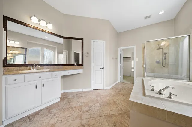 a large bathroom with a granite countertop tub shower sink and mirror