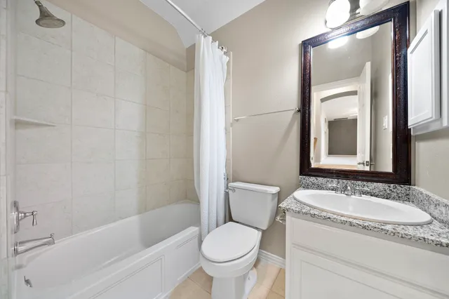 a bathroom with a granite countertop toilet sink and mirror