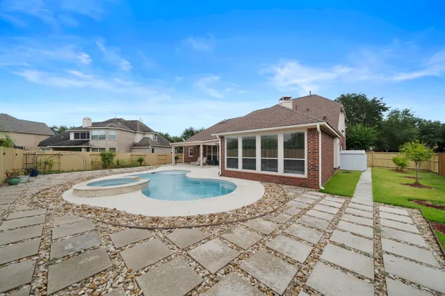 a view of a house with a swimming pool and sitting area
