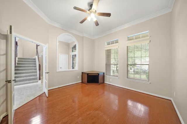 a view of an empty room with a window and a kitchen