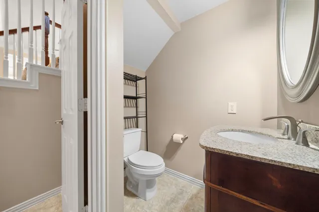 a bathroom with a granite countertop sink toilet and shower a mirror