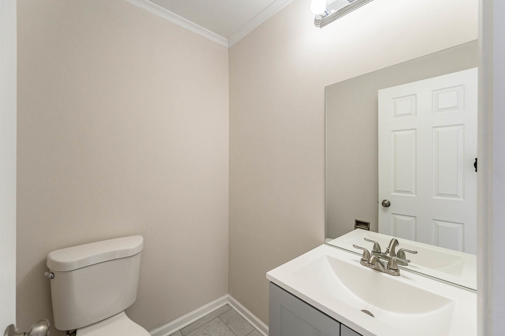 2284 North Pheasant Ridge Court Round Lake Beach, IL 60073 - Photo 3 of 11 a bathroom with a sink a toilet and a mirror