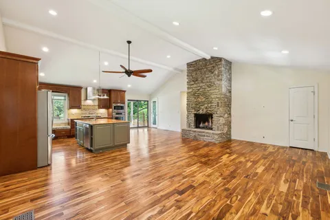 a view of empty room with wooden floor and fireplace