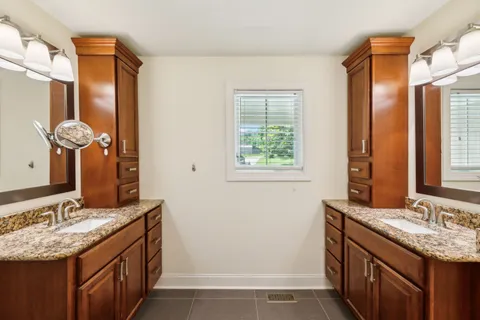 a bathroom with a sink vanity granite and a mirror
