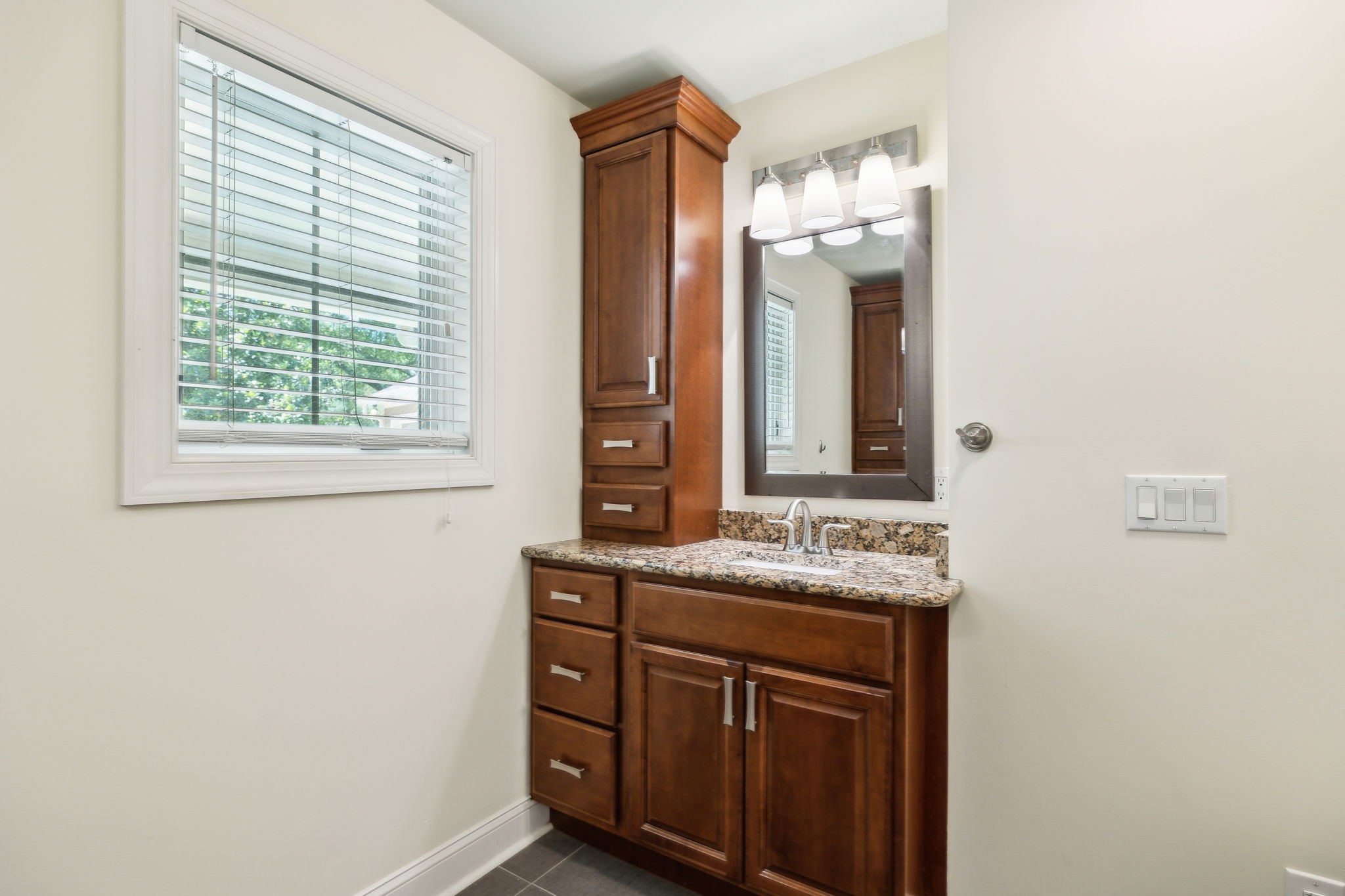 8166 Poplar Creek Road Nashville, TN 37221 - Photo 22 of 63 a bathroom with a sink a mirror and a window
