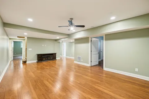 a view of a hallway with wooden floor and staircase